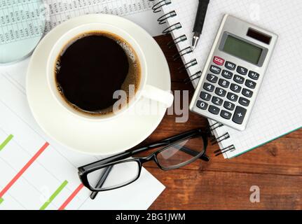 Cup of coffee on worktable covered with documents close up Stock Photo
