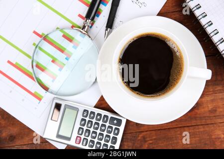 Cup of coffee on worktable covered with documents close up Stock Photo