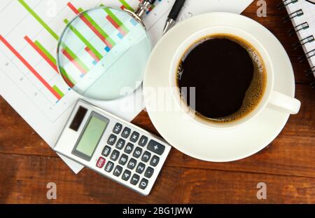 Cup of coffee on worktable covered with documents close up Stock Photo