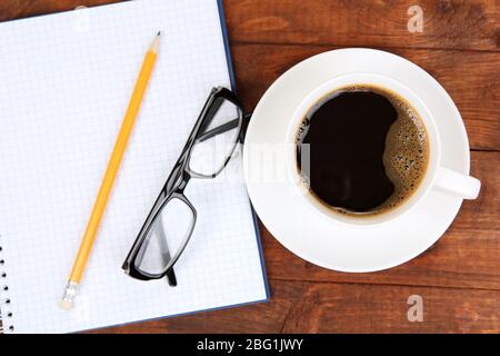 Cup of coffee on worktable covered with documents close up Stock Photo