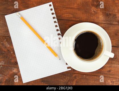 Cup of coffee on worktable covered with documents close up Stock Photo