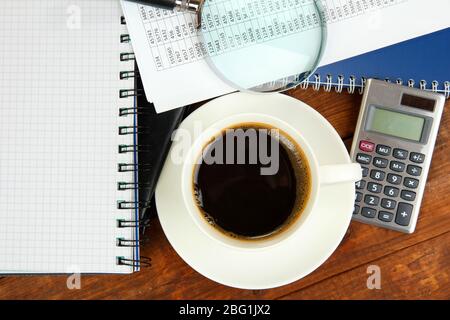 Cup of coffee on worktable covered with documents close up Stock Photo