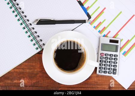 Cup of coffee on worktable covered with documents close up Stock Photo