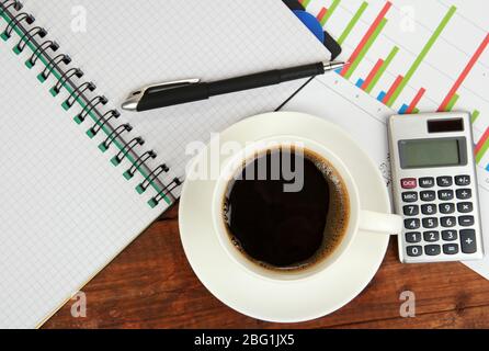 Cup of coffee on worktable covered with documents close up Stock Photo