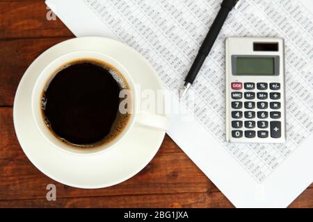 Cup of coffee on worktable covered with documents close up Stock Photo