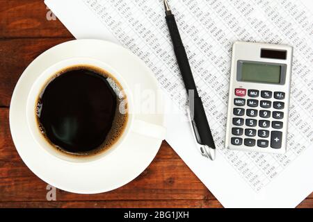 Cup of coffee on worktable covered with documents close up Stock Photo