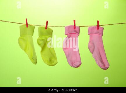 Colorful socks hanging on clothesline, on color background Stock Photo