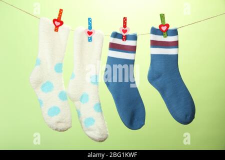 Colorful socks hanging on clothesline, on color background Stock Photo