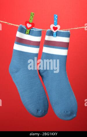 Colorful socks hanging on clothesline, on color background Stock Photo