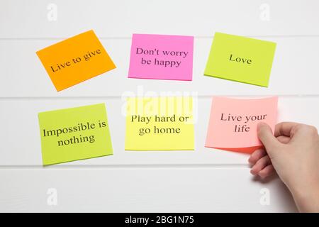 The hand lays out motivational cards. Color sheets with quotes. Visualization Board, self-discipline, development, training. Flat lay, top view. plan, Stock Photo