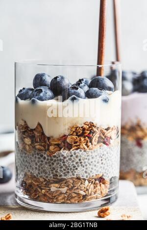 Breakfast parfait with chia, granola, berries and yogurt in a glass. Layer dessert in a glass. Stock Photo