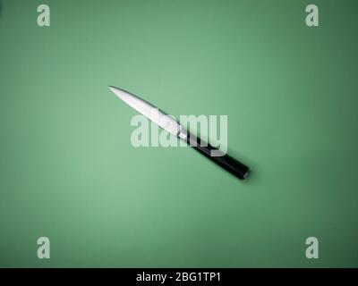 Professional kitchen knife isolated on green background. Stock Photo