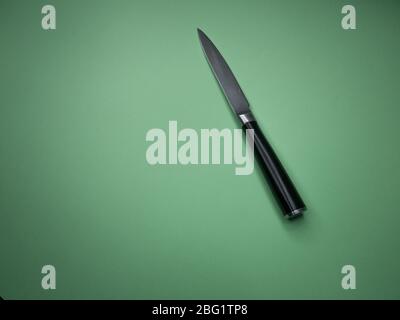 Professional kitchen knife isolated on green background. Stock Photo