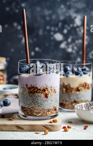 Breakfast parfait with chia, granola, berries and yogurt in a glass. Layer dessert in a glass. Stock Photo