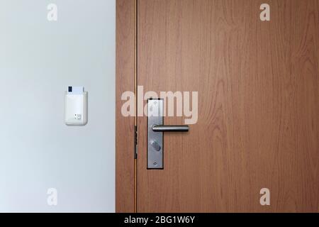 Hotel key card door lock system. Wooden door with electronic lock. Front view. Stock Photo