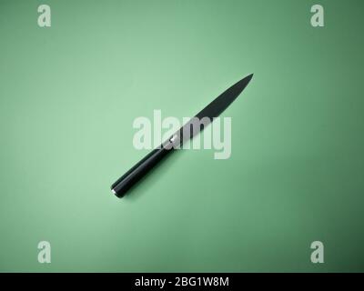 Professional kitchen knife isolated on green background. Stock Photo