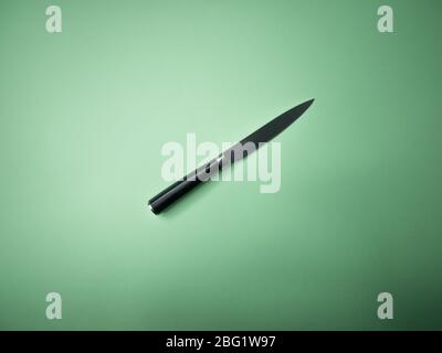 Professional kitchen knife isolated on green background. Stock Photo