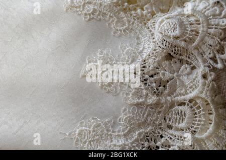 White patterned fabric. Detailed shot of a beautiful fabric. Exquisite fabric with pattern and embroidery. Sewing a wedding dress. Close-up. Selective Stock Photo