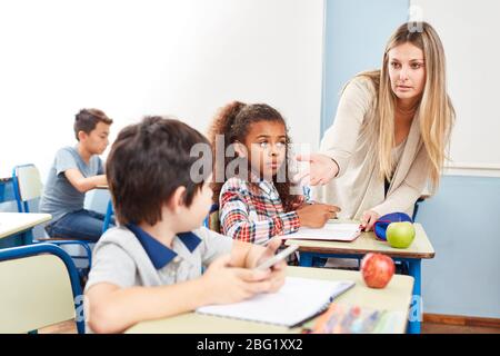 Teacher forbids smartphone use in class and confiscates cellphone from student Stock Photo