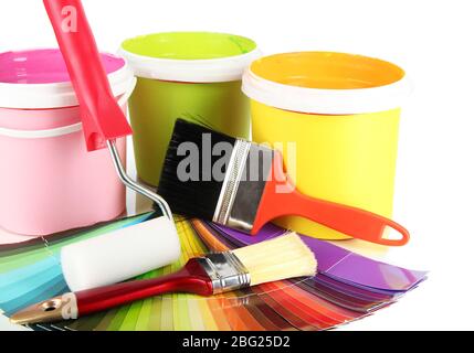 Paint pots, paintbrushes and coloured swatches close up Stock Photo