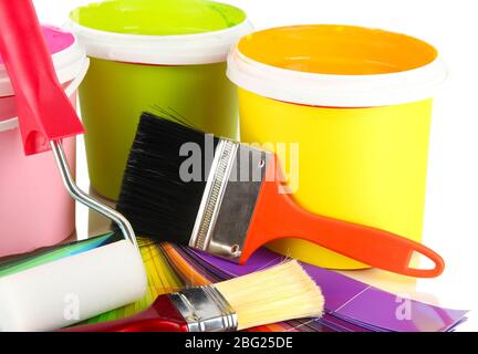 Paint pots, paintbrushes and coloured swatches close up Stock Photo