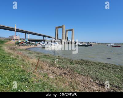 Iwade, Kent, UK. 20th Apr, 2020. Today is the 60th anniversary of the distinctive Kingsferry Bridge, linking Isle of Sheppey with mainland Kent, being opened by the Duchess of Kent on 20 Apr, 1960. At the time it was the largest lifting bridge built in Britain since the Second World War. There is only one other similar design in the world based in Holland. In 2006, the infamous Sheppey Crossing was opened, but Kingsferry was retained for rail and road traffic. A generator is in situ for lifting the centre span as the power system needs a replacement part. Credit: James Bell/Alamy Live News Stock Photo