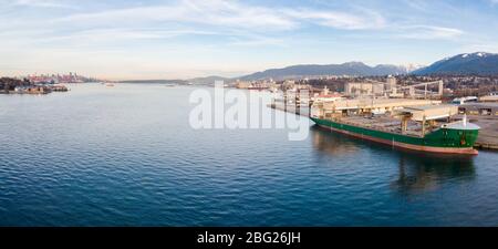 Aerial drone shot of a industrial shipyard and cargo ship loading port with cargo ships in Vancouver, BC, Canada. Stock Photo