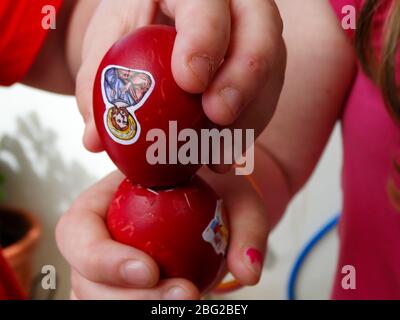 kids hand crushing red easter eggs on happy easter holiday Stock Photo