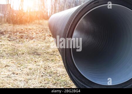 Large diameter black polypropylene pipes for laying communications, drainage systems and heating mains under the road. Modern method and technology fo Stock Photo