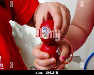 kids hand crushing red easter eggs on happy easter holiday Stock Photo