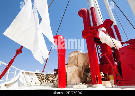 Ship laundry hung out to dry at the bow of the Bou el Mogdad antique river boat on the Senegal River. Stock Photo
