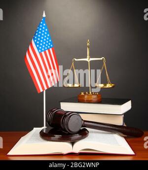 Wooden gavel, golden scales of justice and books on grey background ...