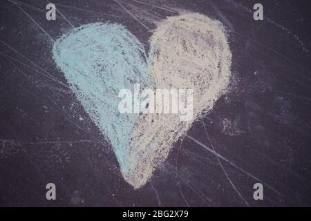 Colorful heart chalk drawing - drawn by a child on a pedestrian pavement, asphalt Stock Photo