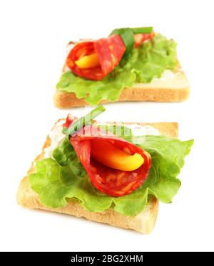 Salami rolls with paprika pieces inside, on  roasted bread, isolated on white Stock Photo