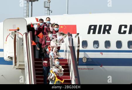 Beijing, China. 20th Apr, 2020. Members of medical assistance team from Chinese Center for Disease Control and Prevention (CDC) supporting virus-hit Hubei Province get off the airplane at Beijing Capital International Airport in Beijing, capital of China, April 20, 2020. China's National Health Commission on Monday held a ceremony at Beijing Capital International Airport to welcome the returned medical assistance team from Chinese Center for Disease Control and Prevention (CDC) supporting the virus-hit Hubei Province. Credit: Chen Jianli/Xinhua/Alamy Live News Stock Photo