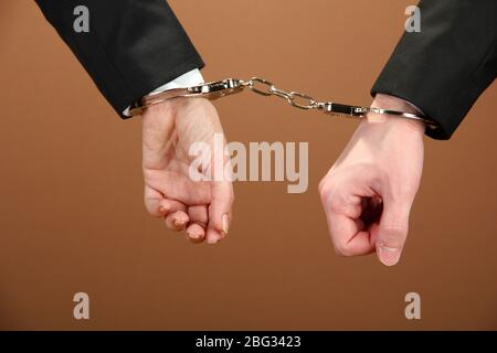 Man and woman hands and breaking handcuffs on color background Stock Photo