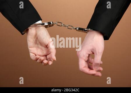 Man and woman hands and breaking handcuffs on color background Stock Photo