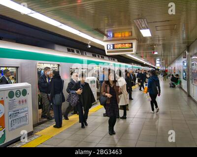 Commuters leave a crowded train on the busy subway / underground at a station in Kyoto, Japan. Stock Photo