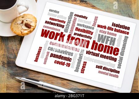 work from home word cloud on a digital tablet with a cup of coffee, social distancing, self quarantine and stay-at-home order during covid-19 coronavi Stock Photo
