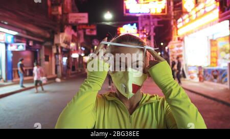 Woman close up look caucasian at Pattaya Walking Street with wearing protective medical mask. Lockdown quarantine isolation. Coronavirus covid-19. Stock Photo