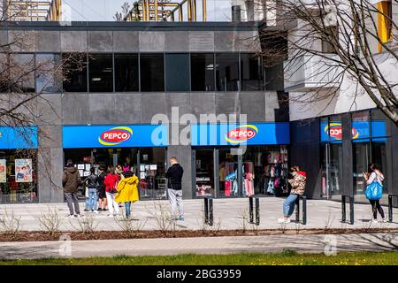 Warsaw, Mazovia / Poland - 2020/04/18: Customers queuing for sanitary products as per COVID-19 social distancing restrictions in Ursynow district Stock Photo