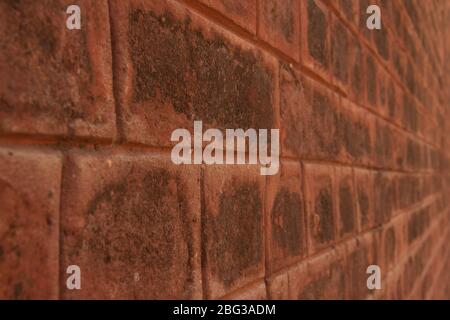 Close up of an old orange brick wall in perspective fading in bokeh background Stock Photo