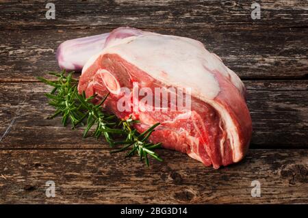 Studio shot of a shoulder of lamb resting on a rustic, dark wooden background Stock Photo