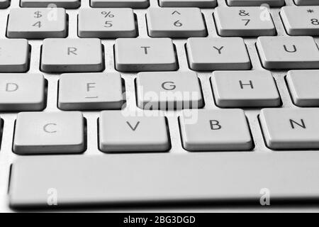 Close-up image of the middle section of a silver coloured computer keyboard clearly showing white keys 4, 5, 6, 7, R, T, Y, F, G, H, V, B and N with a Stock Photo