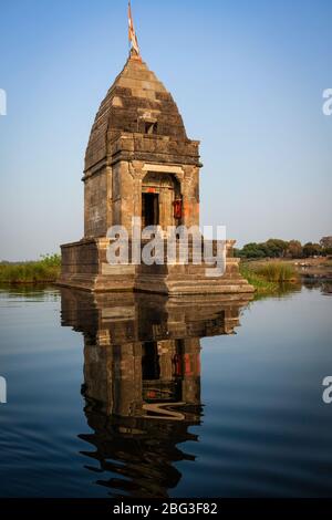 Small Hindu temple in the middle of the holy Narmada River, Maheshwar, Madhya Pradesh state, India Stock Photo