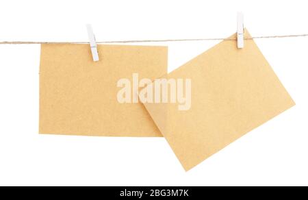 Old sheets of paper hanging on rope isolated on white Stock Photo