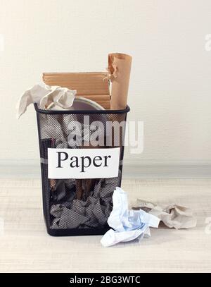 Assorted trash in bucket on room background Stock Photo