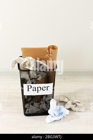 Assorted trash in bucket on room background Stock Photo