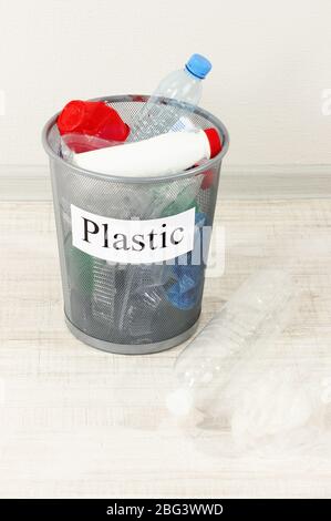 Assorted trash in bucket on room background Stock Photo