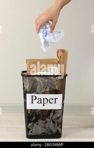 Assorted trash in bucket on room background Stock Photo